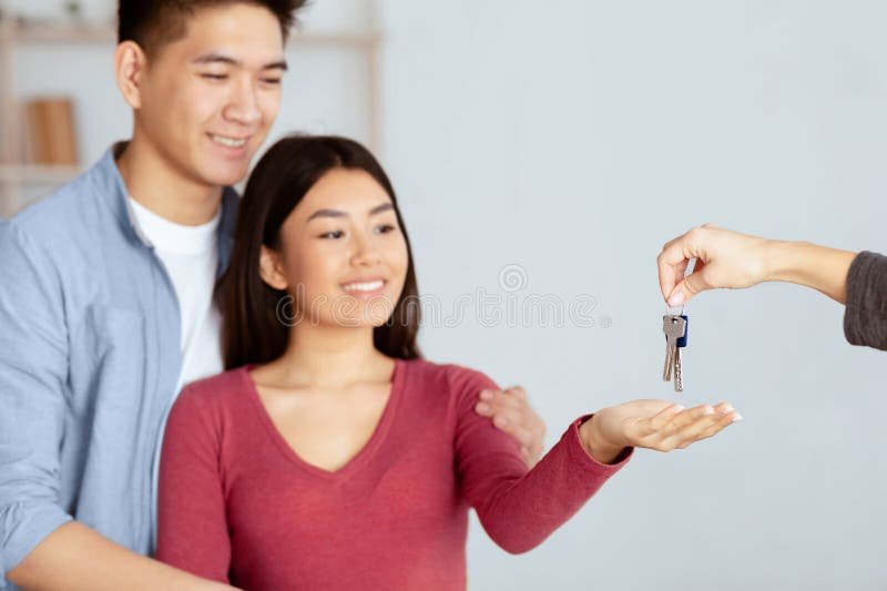 agente immobiliare che mostra chiavi a inquilino contento