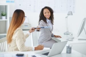 colleghi che si passano documenti in ufficio