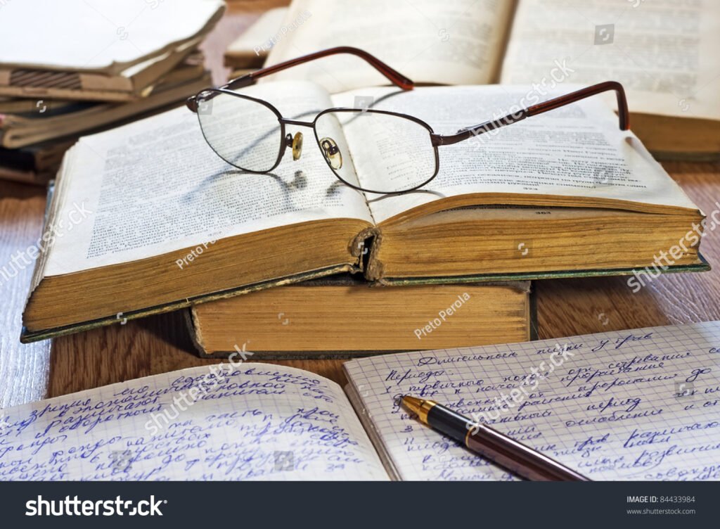 libro aperto con penna e occhiali