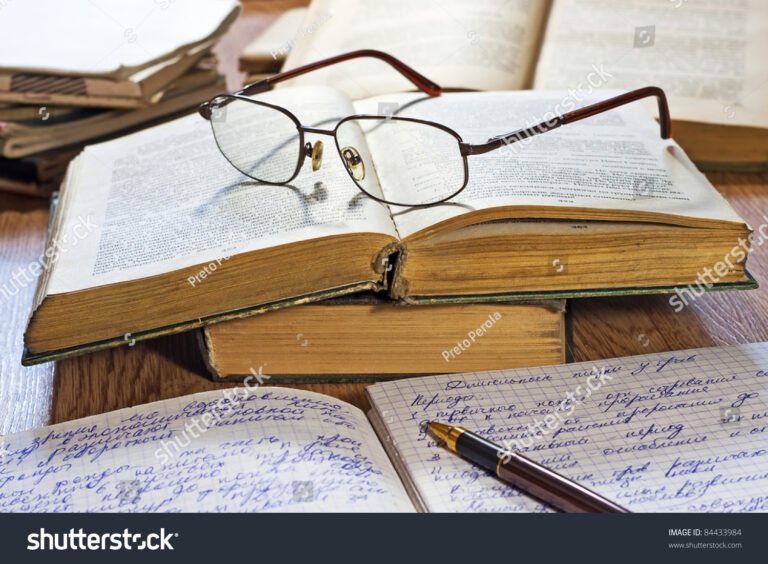 libro aperto con penna e occhiali