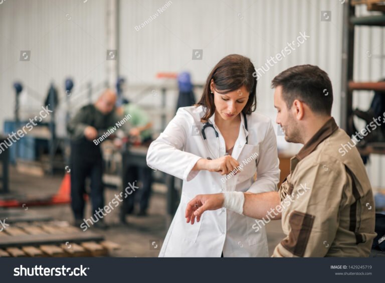 medico che esamina un lavoratore in fabbrica