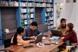 persone che studiano insieme in biblioteca moderna