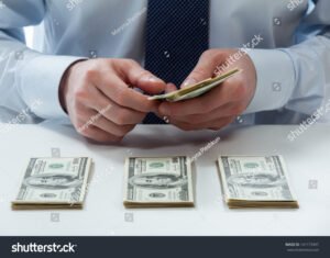 una mano che conta banconote su tavolo